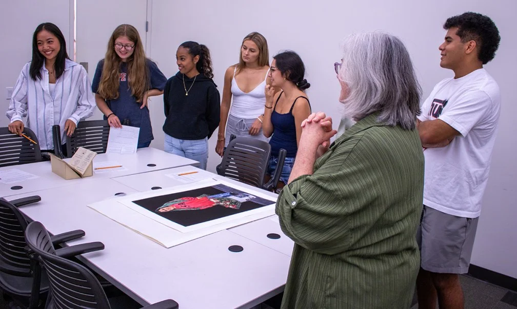six students listening to librarian talk about special collections objects